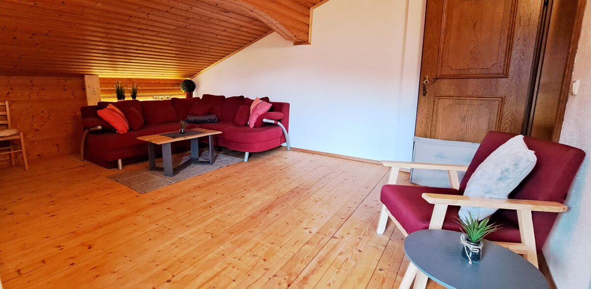 Wohnzimmer mit Couch, Sessel und Beistelltisch